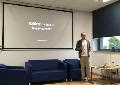 Podróżnik Piotr Kowalczyk na tle ekranu z pokazem slajdów