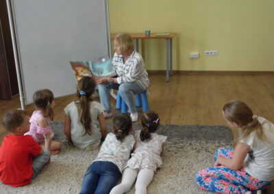 Gość spotkania pani Emilia Koronka czyta dzieciom książkę