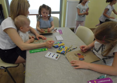 Dzieci wykonujące prace plastyczne podczas spotkania z książką