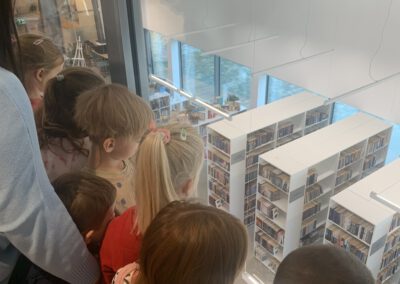 Dzieci zwiedzają bibliotekę w Komornikach podczas lekcji bibliotecznej.